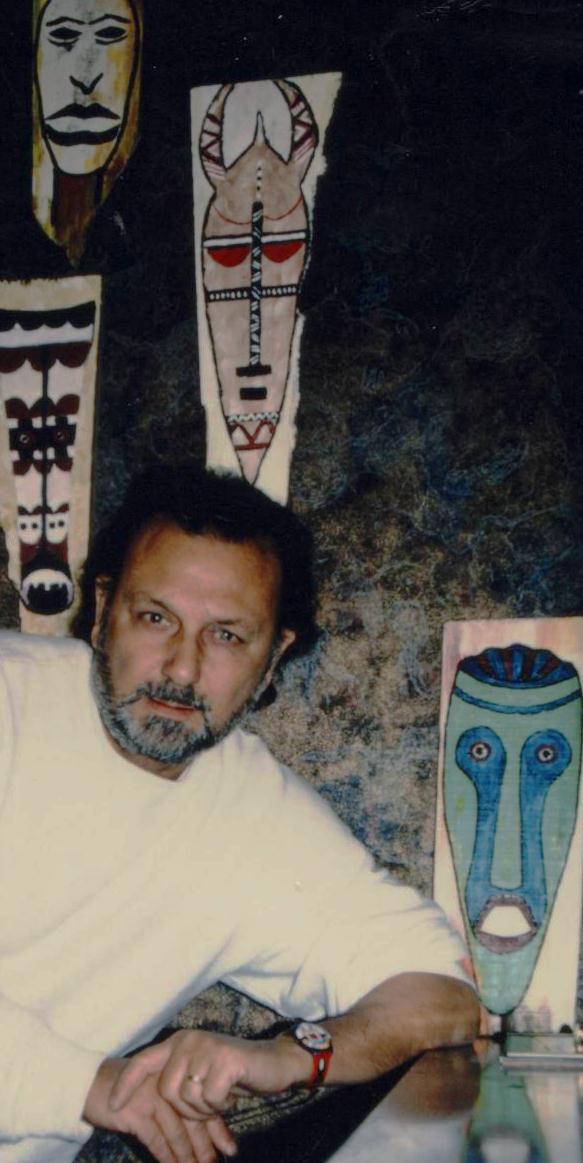Roger Macchi, plus jeune, devant ses totems peints